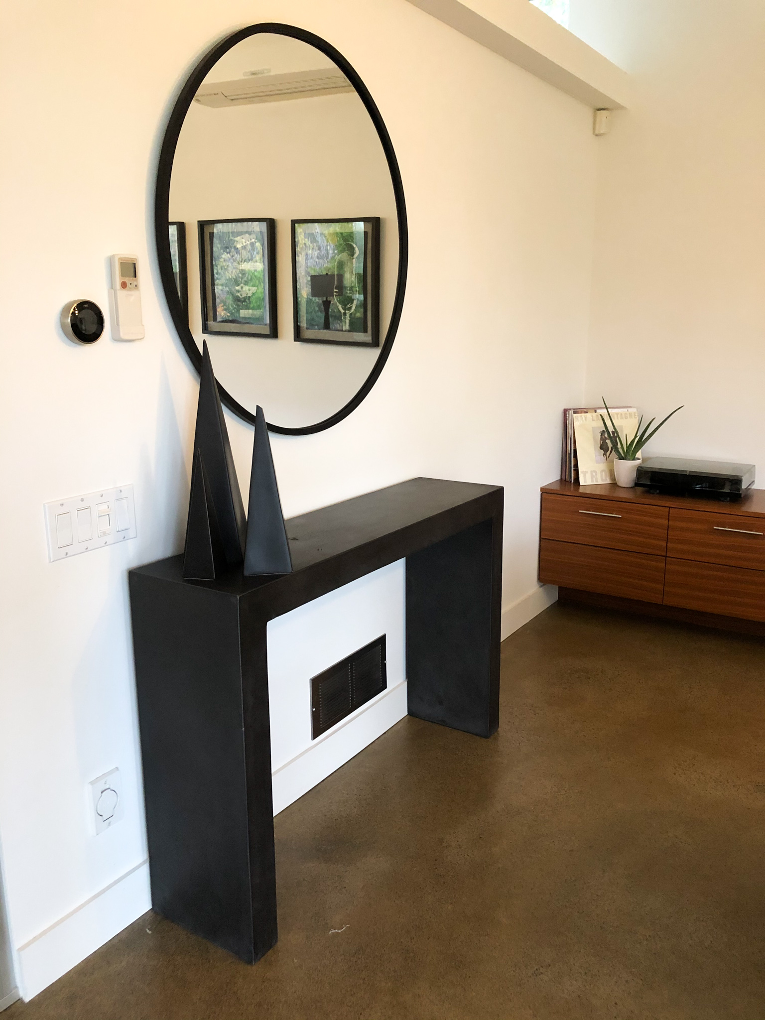 Black Console table with accessories on top and round mirror above